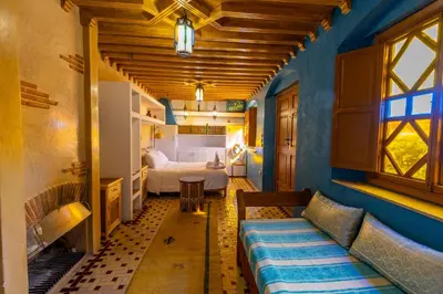 a room with a bed and a couch and a bedroom at Riad Aicha Marrakech in Marrakech