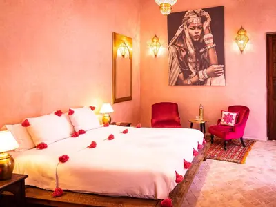 a bedroom with a large bed with roses on it at Riad Selouane in Marrakech