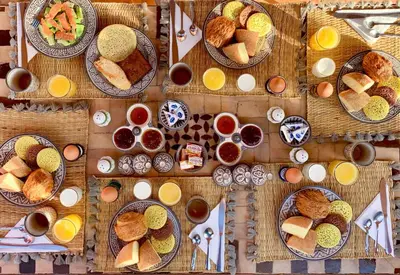 a table filled with plates of food and bowls of bread at Riad Selouane in Marrakech