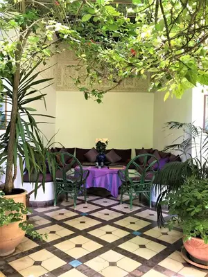 a room with a table and chairs and plants at Riad Sahara Nour in Marrakech