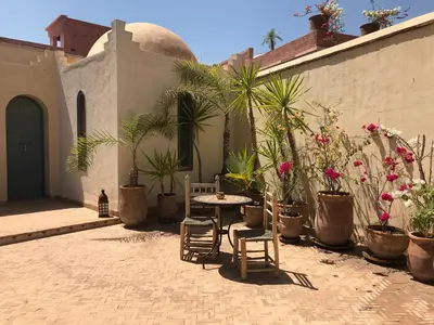 a patio with a table and chairs and plants at Riad Sahara Nour in Marrakech
