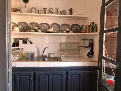 a kitchen with a sink and shelves with dishes at Dar Christine in Marrakech