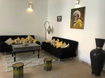 a living room with two black couches and a table at Dar Christine in Marrakech