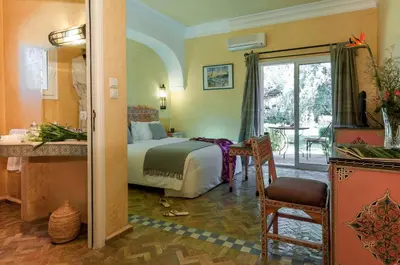a hotel room with a bed and a balcony at Charming villa in the heart of Marrakech palm grove in Marrakech