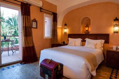 a bedroom with a large bed and a large window at Charming villa in the heart of Marrakech palm grove in Marrakech
