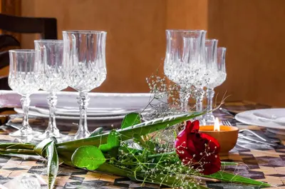 a table with wine glasses and a red rose on it at Charming villa in the heart of Marrakech palm grove in Marrakech