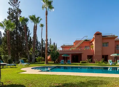 a resort with a swimming pool and palm trees at Charming villa in the heart of Marrakech palm grove in Marrakech