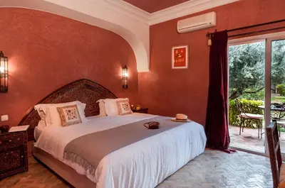 a bedroom with a large bed and a large window at Charming villa in the heart of Marrakech palm grove in Marrakech