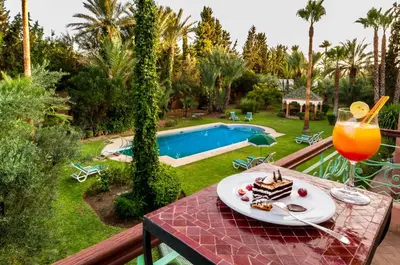 a table with a piece of cake and a drink at Charming villa in the heart of Marrakech palm grove in Marrakech