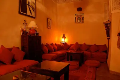 a living room with a red couch and a table at Riad Massiba in Marrakech