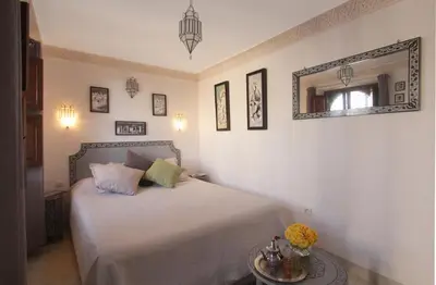 a bedroom with a bed with a mirror and a table at Riad Massiba in Marrakech