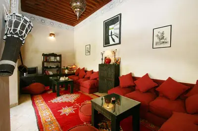 a living room with a red couch and red pillows at Riad Massiba in Marrakech