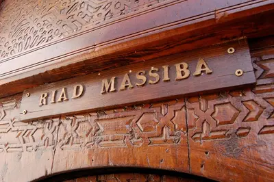 a wooden door with a sign that reads had malsisba at Riad Massiba in Marrakech