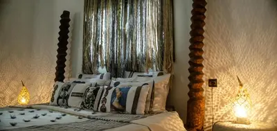a bedroom with a canopy bed with pillows at Riad les Ammonites and Spa in Marrakech