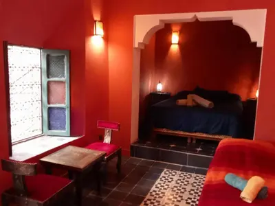 a bedroom with a bed and a table and a window at Riad JEREMY in Marrakech