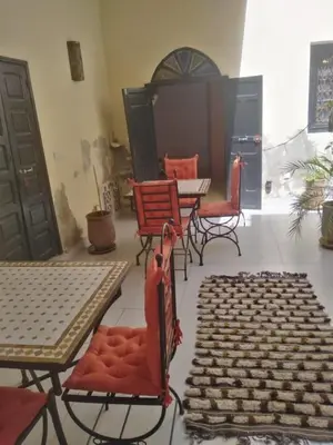 a room with chairs and tables and a table with a rug at Riad JEREMY in Marrakech