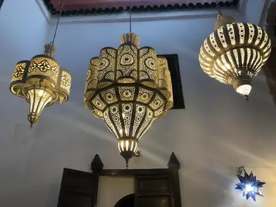 a group of lights hanging from a wall at RIAD DES DEUX MERS in Marrakech