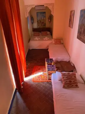 a room with four beds in a room with a hallway at RIAD DES DEUX MERS in Marrakech