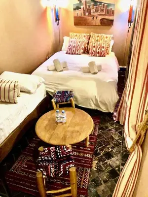 a room with two beds and a table in a room at RIAD DES DEUX MERS in Marrakech