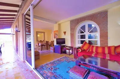 a living room with a red couch and a tv at Hacienda Marrakech in Marrakech