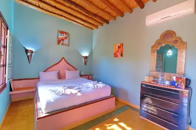 a bedroom with a bed and a dresser in it at Hacienda Marrakech in Marrakech