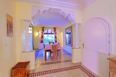 a dining room with a table and an archway in a house at Hacienda Marrakech in Marrakech