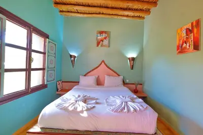 a bedroom with a large bed with white sheets at Hacienda Marrakech in Marrakech