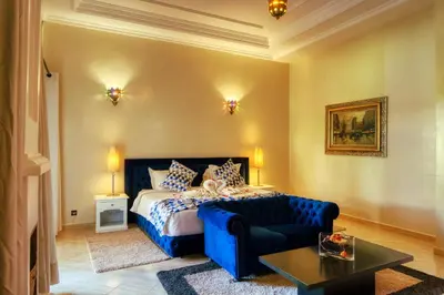 a bedroom with a blue bed and a couch at Villas 95 Appart'Hôtel in Marrakech