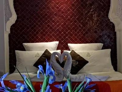 two swans are forming a heart on a bed at Riad Charme d'Orient Adults Only in Marrakech