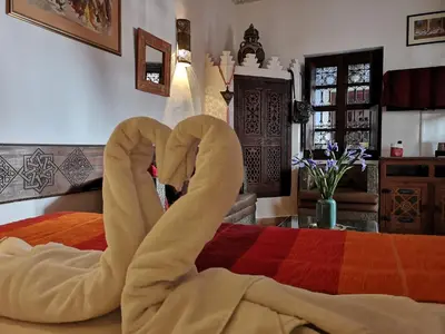 a bed with a pair of swans made to look like hearts at Riad Charme d'Orient Adults Only in Marrakech
