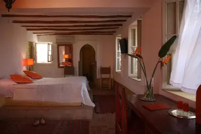 a bedroom with a bed in a room with windows at Riad Spa Dar Nimbus in Marrakech