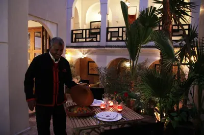 a man standing in front of a table with a pan at Riad Spa Dar Nimbus in Marrakech