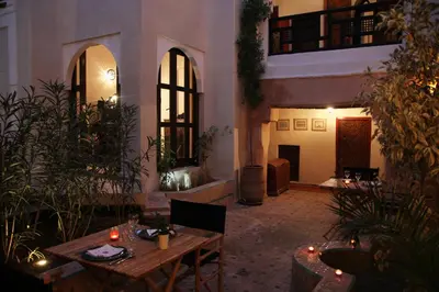 a patio with tables and plants in a building at Riad Spa Dar Nimbus in Marrakech