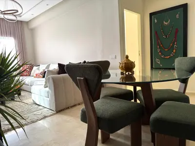 a living room with a glass table and chairs at Caprice Palace in Marrakech