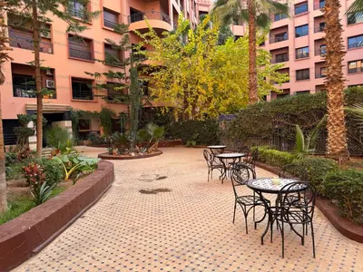 a courtyard with tables and chairs in a building at Caprice Palace in Marrakech