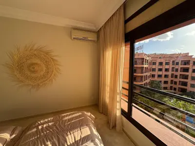 a bedroom with a bed and a large window at Caprice Palace in Marrakech