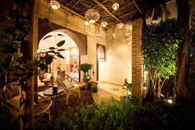 a living room with a couch and chairs in a building at Riad Dar Amanza en exclusivité avec 4 chambres au coeur de la médina in Marrakech
