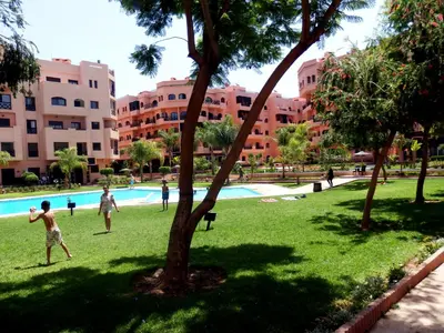 a group of people playing soccer in a park at Appart Piscine Jardin somptueux à 2 min de palmeraie et 10 min de Majorelle in Marrakech