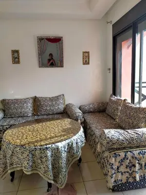 a living room with a couch and a table at Appart Piscine Jardin somptueux à 2 min de palmeraie et 10 min de Majorelle in Marrakech