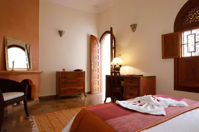 a bedroom with a bed and a dresser and a window at Riad Daria Suites & Spa in Marrakech