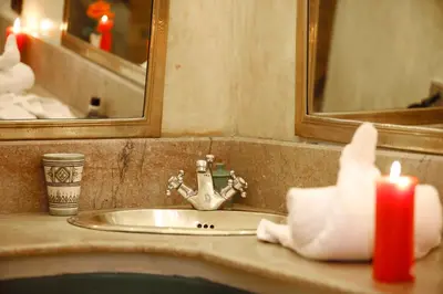 a bathroom sink with a red candle and a mirror at Riad Daria Suites & Spa in Marrakech