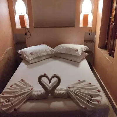 two hearts are laying on a bed in a room at Riad Laith in Marrakech