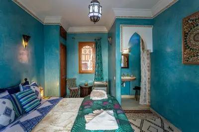 a blue room with a bed and a sink at Riad Bianca Marrakech in Marrakech