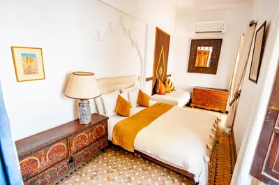 a bedroom with a bed and a lamp on a table at Hotel & Spa Riad Dar El Aila in Marrakech