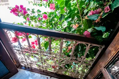 a garden with pink flowers behind a fence at Hotel & Spa Riad Dar El Aila in Marrakech