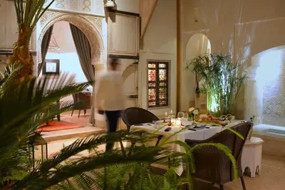 a person walking around a dining room with a table at Riad Dar Housnia in Marrakech
