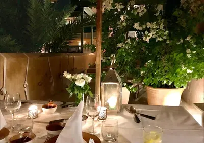 a table with wine glasses and flowers on it at Riad Dar Housnia in Marrakech
