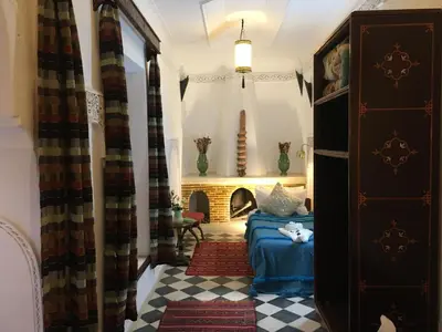a living room with a couch and a fireplace at Riad Blue Berber in Marrakech