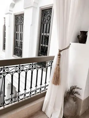 a white curtain on a balcony with windows at Riad Louhou in Marrakech