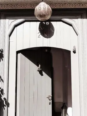 a door to a building with a chandelier above it at Riad Louhou in Marrakech